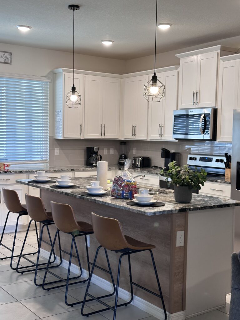 Spotless Airbnb kitchen featuring a breakfast nook (copa) after a detailed cleaning by Velura Clean. All surfaces sanitized, dishes organized, floors mopped, and appliances gleaming. Ready for incoming guests in Ocoee, Orlando area, Florida.